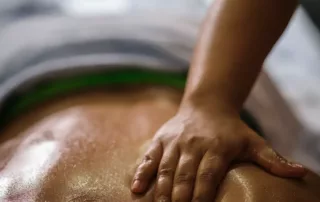 Eine entspannende Massage in einem Wellnesshotel, bei der eine Hand sanft über den Rücken gleitet, ideal für Erholung und Wellness.