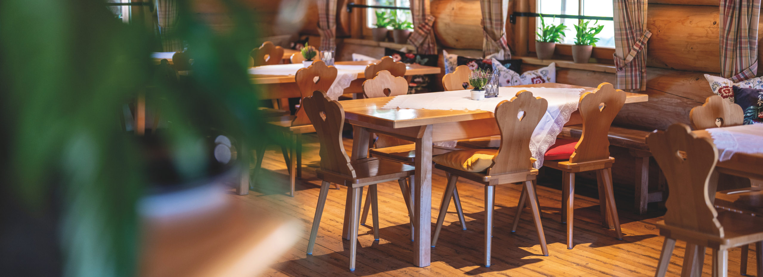 Der Speisesaal im Hotel Almrausch zeigt Holzstühle und Tische in einer warmen, einladenden Atmosphäre für Familienurlaube.